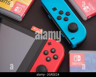 Tambov, Fédération de Russie - 28 septembre 2021 Nintendo Switch console de jeux vidéo avec un joy-con bleu et des boîtes de jeux vidéo à proximité. Banque D'Images