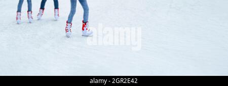 Jambes patinant sur glace. Longue bannière pour les sports d'hiver avec espace de copie. Les gens font du patinage sur glace dans des patins loués Banque D'Images