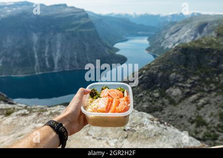 Saumon de ferme norvegien dans une boîte à lunch au fond des montagnes, Trolltunga, comté de Vestland, Norvège Banque D'Images