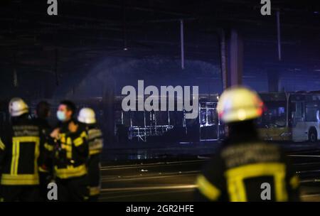 Stuttgart, Allemagne. 30 septembre 2021. Les pompiers se tiennent à côté des bus brûlés dans un dépôt. Dans la soirée, un incendie s'est déclaré au dépôt d'autobus de l'autorité de transport de Stuttgart. Crédit : Tom Weller/dpa/Alay Live News Banque D'Images