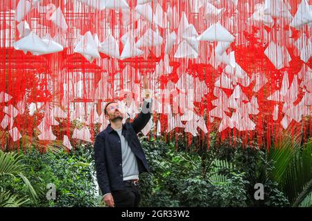 Kew Gardens, Londres, Royaume-Uni. 30 septembre 2021. Kew Staffer Paul avec l'œuvre d'art immersive à grande échelle One Thousand Springs par l'artiste japonais Chiharu Shiota, une œuvre d'art contemporaine qui pend du plafond de la Temperate House composée de 5,000 haikus suspendus dans un réseau de fils rouges. Le Japan Festival à Kew est un nouveau festival d'automne immersif célébrant les arts, les plantes et la culture du Japon avec des installations à grande échelle et de magnifiques expositions horticoles qui prennent le contrôle de la Temperate House pour le mois d'octobre. Credit: Imagetraceur/Alamy Live News Banque D'Images