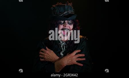 La vieille femme créepy dans le costume de sorcière d'Halloween hurle de problèmes de stress se sent horreur désespoir Banque D'Images