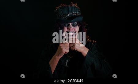 Bouleversé déçu femme sinistre en costume de sorcière d'Halloween essuie les larmes et les cris de désespoir Banque D'Images