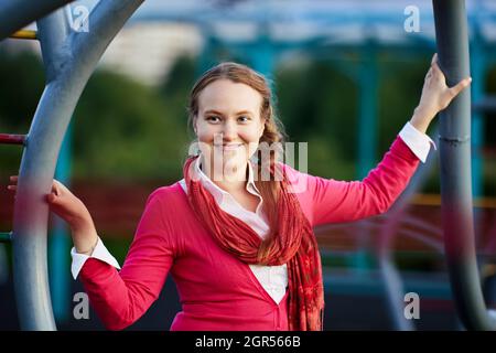 Une femme européenne heureuse en foulard marche à l'extérieur. Banque D'Images