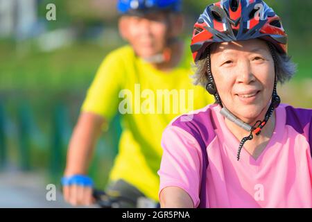 Joyeux couple senior s'entraîner avec des vélos dans le parc Banque D'Images