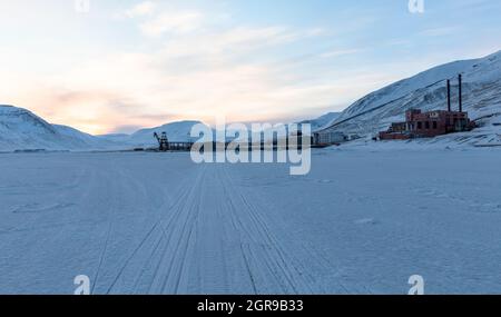 Pyramiden, Svalbard. Les pistes de motoneige sur la glace de mer, menant à Pyramiden port. Banque D'Images