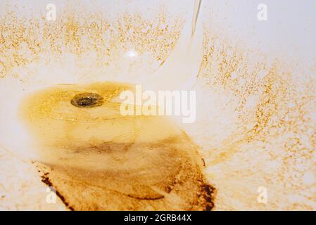 De l'eau rouillée s'écoule du robinet dans la salle de bains Banque D'Images