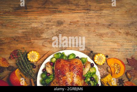 dinde de Thanksgiving ou poulet pour un dîner de fête. Arrière-plan de la table de nourriture avec des spécialités saisonnières d'automne pour le jour de Thanksgiving. Poulet frit avec citrouille, légumes et décoration d'automne sur fond de table en bois. Photo de haute qualité Banque D'Images