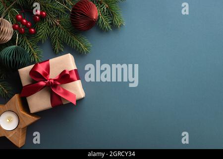 Fond turquoise foncé avec boîte cadeau de Noël et porte-bougie en bois. Banque D'Images