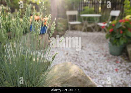 Jardin de pierre au coucher du soleil avec table basse de bistro vide sur fond flou Banque D'Images