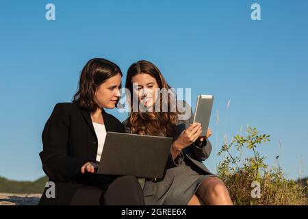 Femmes d'affaires travaillant avec un ordinateur portable et une tablette en montagne Banque D'Images