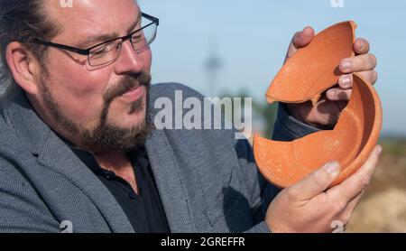 Deiningen, Allemagne. 1er octobre 2021. L'archéologue Manfred Woidlich tient un bol en céramique cassé avec des gravures. Au cours des fouilles dans les Ries de Nördlinger, les archéologues ont trouvé ce bol, originaire d'Afrique, entre autres biens graves dans une tombe du 6ème siècle. Credit: Stefan Puchner/dpa/Alay Live News Banque D'Images