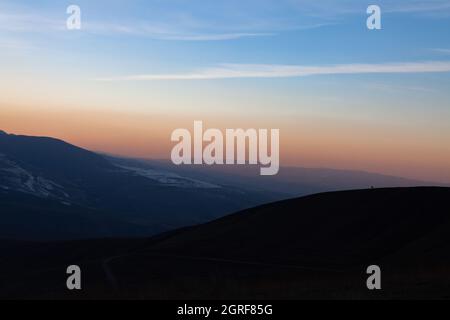 Avant le coucher du soleil, un cheval solitaire se dresse au sommet de la montagne. Les montagnes Majestic Tian Shan Banque D'Images