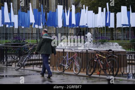 Une personne passe devant Luke Jerram à Memoriam, une installation artistique puissante et importante, créée en mémoire des pertes subies pendant la pandémie de COVID-19, après son installation dans le College Green de Bristol. L'installation, qui sera ouverte au public du 1er au 17 octobre, est composée de plus de 100 drapeaux fabriqués à partir de draps de lit d'hôpital NHS. Date de la photo : vendredi 1er octobre 2021. Banque D'Images