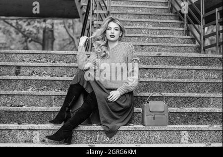 belle journée. fille en jupe ondulée et chandail. Tendance plissée. Automne femme cheveux bouclés en plein air. Décontracté style étudiant. Automne. Fille longue blonde Banque D'Images