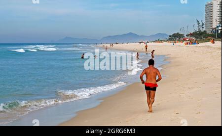 RIO DE JANEIRO, BRÉSIL - 14 NOVEMBRE 2015 : homme courant sur la plage de Barra da Tijuca Banque D'Images