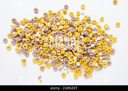 Boucles de fruits de céréales multicolores sur fond blanc. Gros plan. Concept petit déjeuner Banque D'Images