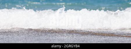 Grande et forte onde de tempête de couleur turquoise parsemée de moussage blanc et de pauses sur le rivage Banque D'Images