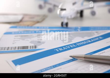 Contrat d'assurance médicale pour les touristes stylo et avion sur table Banque D'Images
