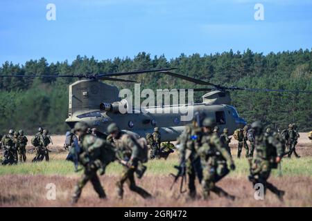 01 octobre 2021, Saxe-Anhalt, Klietz: Des soldats du Falschirmjäger Regiment 26 appartenant à la 'Division Schnelle Kräfte' (DSK) quittent un hélicoptère Chinook C-47 de l'armée américaine, tandis que d'autres Falschirmjäger entrent dans l'hélicoptère. Avec l'exercice 'Green Griffin 21', le DSK forme des opérations de combat dans le cadre de la défense nationale et de l'alliance depuis le 27 septembre 2021 dans les zones d'entraînement militaire de Klietz, Altengrabow, Lehnin et Stendal ainsi qu'au Centre d'entraînement et d'exercice Air Mobility de celle. Outre les parachutistes allemands, les soldats néerlandais et les troupes de Banque D'Images