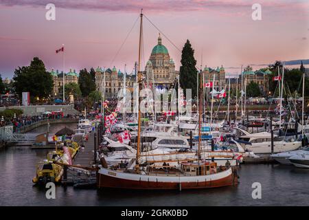 Fête du Canada à Victoria, île de Vancouver, Canada. Des masses de personnes visitant les célébrations à l'intérieur du port avec le bâtiment du Parlement pendant le soleil Banque D'Images