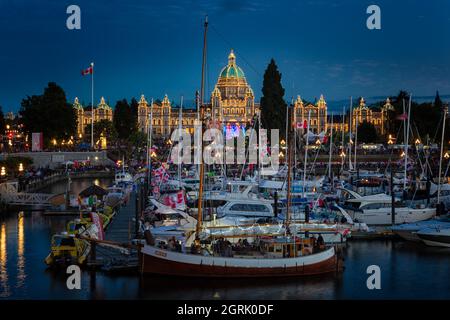 Fête du Canada à Victoria, île de Vancouver, Canada. Des masses de personnes visitant les célébrations à l'intérieur du port avec le bâtiment du Parlement pendant le soleil Banque D'Images