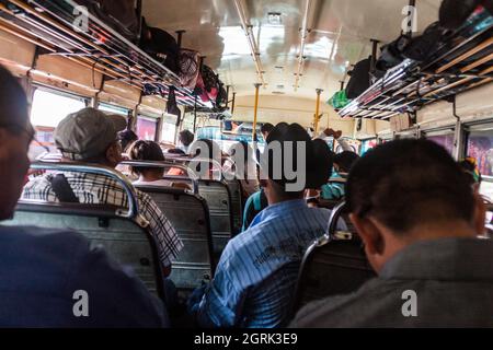 QUETZALTENANGO, GUATEMALA - 21 MARS 2016 : les gens se trouvent dans un bus à poulet, ancien bus scolaire américain. Banque D'Images