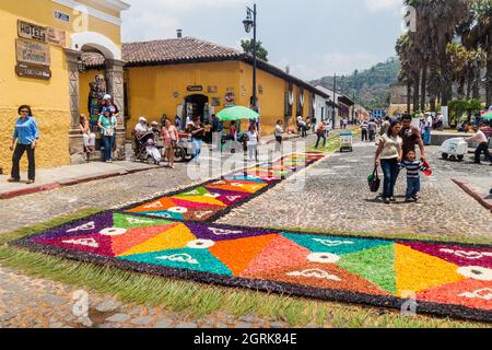 ANTIGUA, GUATEMALA - 27 MARS 2016: Les gens marchent le long des tapis décoratifs de Pâques dans la ville d'Antigua Guatemala, Guatemala. Banque D'Images