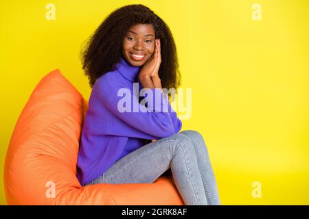 Portrait de profil de la personne belle peau sombre mains paumes ensemble sur joue isolé sur fond jaune Banque D'Images