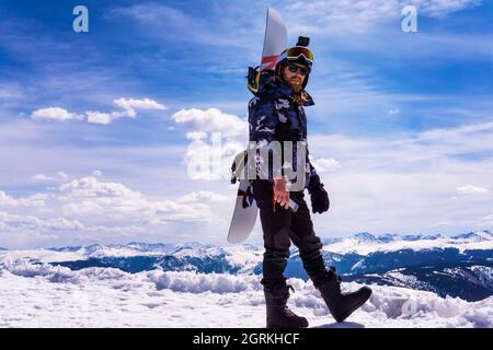 Homme avec planche à neige dans l'extrême hiver Snow Mountain Resort Banque D'Images