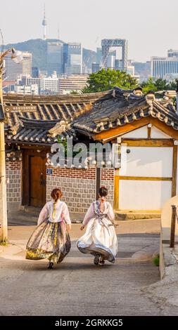 Séoul, Corée du Sud - 21 juin 2017 : deux jeunes femmes en hanbok coloré dans le village de Bukchon Hanok à Séoul. Banque D'Images