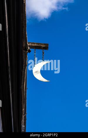 L'ancien panneau de pub pour le pub en demi-lune de Little St Marys Lane à Cambridge, en Angleterre, contre le ciel bleu clair Banque D'Images