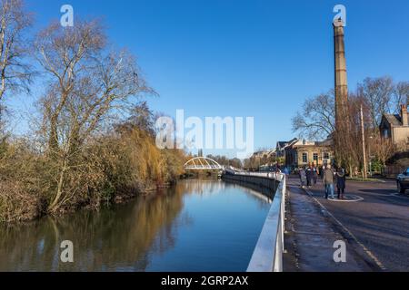 Vue sur la rivière calme avec pont de pieds blancs et la grande vieille cheminée de la station de pompage au Musée de technologie de Cambridge sur Riverside Banque D'Images