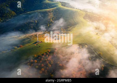 Le brouillard matinal s'étend sur des prairies verdoyantes dans les montagnes d'automne. Montagnes carpathiennes ukrainiennes. Photographie de paysage Banque D'Images