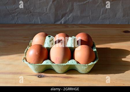 HAYDOCK. ST.HELENS. LANCASHIRE. 10-01-21. Une demi-douzaine d'œufs de taille moyenne dans une boîte. Le fond est une planche à découper en bois. Les oeufs portent le li Banque D'Images