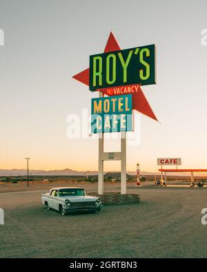 Suivez les panneaux indiquant Roys Motel & Cafe sur la route 66 dans le désert de Mojave en Californie Banque D'Images