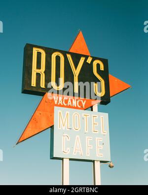 Suivez les panneaux indiquant Roys Motel & Cafe sur la route 66 dans le désert de Mojave en Californie Banque D'Images