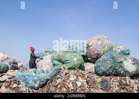 Nakuru, Vallée du Rift, Kenya. 1er octobre 2021. Une femme est vue trier les déchets de bouteilles en plastique sur le site de déchargement de Gioto pour être emmenée dans une installation de recyclage à proximité.le problème croissant des déchets en plastique se terminant dans l'environnement devient une préoccupation et les environnementalistes appellent à plus d'investissements dans l'infrastructure de recyclage du plastique pour promouvoir circulaire économie et réduire la pollution plastique. Ils demandent également au gouvernement d'introduire un système obligatoire de dépôt et de remboursement des bouteilles (DRS) qui donnera de la valeur aux bouteilles de boisson en plastique communément appelées animaux de compagnie (polyéthylène téréphtalate). De Cr Banque D'Images