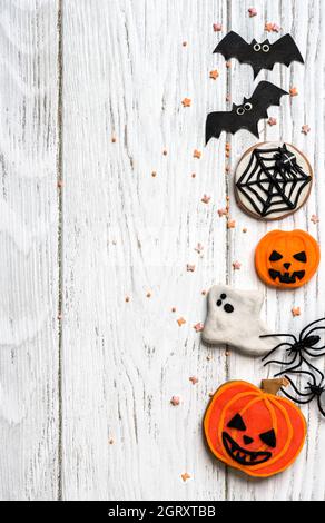 Arrière-plan Halloween avec biscuits, fantôme et chauves-souris, vue du dessus. Halloween objets drôles sur table blanche en bois avec espace pour le texte, plat. Hallowen foo Banque D'Images
