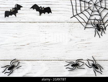 Arrière-plan Halloween avec araignées, toile et chauves-souris, vue du dessus. Objets d'Halloween sur table en bois blanc avec espace pour le texte, plat. Minimaliste de Hallowen Banque D'Images