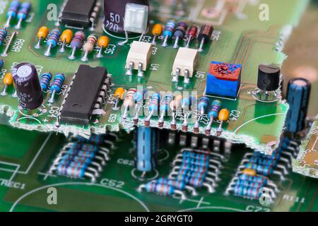 Gros plan des déchets électroniques de circuits imprimés verts cassés avec technologie de composants traversants. Recyclage des déchets électroniques en génie électrique. Banque D'Images