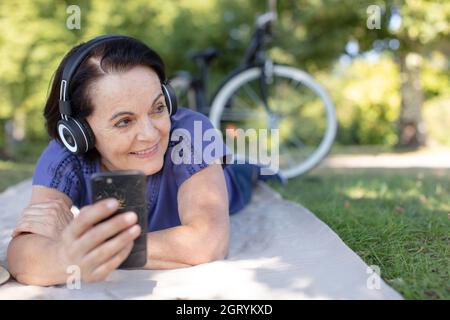 une jolie femme senior prend un selfie dans un parc de la ville Banque D'Images