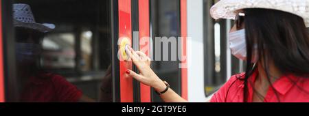 Femme touriste dans masque médical de protection en appuyant sur le bouton pour ouvrir la porte du train Banque D'Images