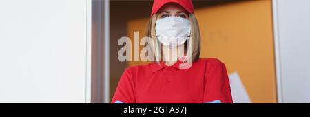 Portrait d'une femme courier dans un masque médical de protection en uniforme Banque D'Images