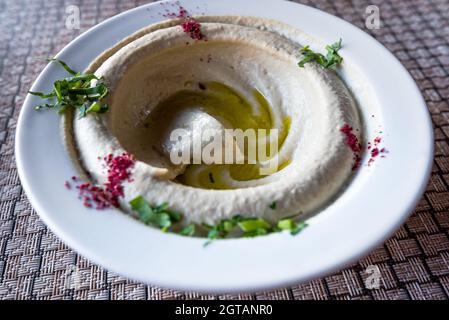 Houmous, humus sur un plat, entrée traditionnelle au Moyen-Orient. Wadi Musa, Petra en Jordanie, cuisine locale jordanienne. Banque D'Images