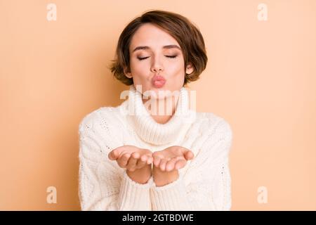 Photo portrait de belle fille avec bob coiffure envoi air baiser sur Saint Valentin romantique isolé sur fond de couleur beige pastel Banque D'Images