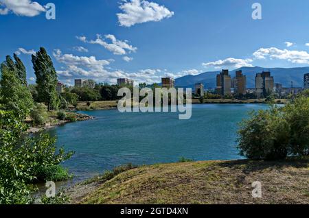 Panorama d'automne d'une partie du quartier au bord du lac avec arbres verts, arbustes et herbe brûlée, Drujba, Sofia, Bulgarie Banque D'Images