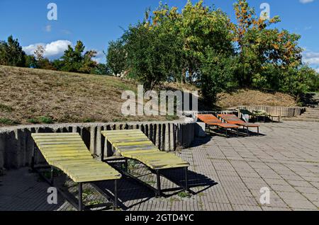 Panorama d'automne depuis une partie d'un quartier résidentiel près d'un lac avec des arbres verts, des buissons et des lits en bois pour bronzer, Drujba, Sofia, Bulgarie Banque D'Images