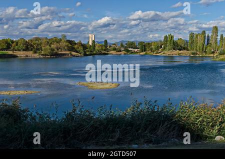 Panorama d'automne d'une partie du quartier au bord du lac avec arbres verts, arbustes et herbe brûlée, Drujba, Sofia, Bulgarie Banque D'Images