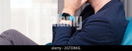 Homme anonyme non reconnaissable portant une montre Apple Watch sur son poignet gros plan, gros plan, main sous le menton. Apple Company, système iOS, gadgets personnels, suivant Banque D'Images